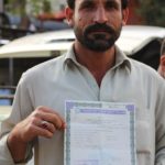 Arshad Hussain shows his papers