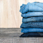 Jeans stacked on a wooden table